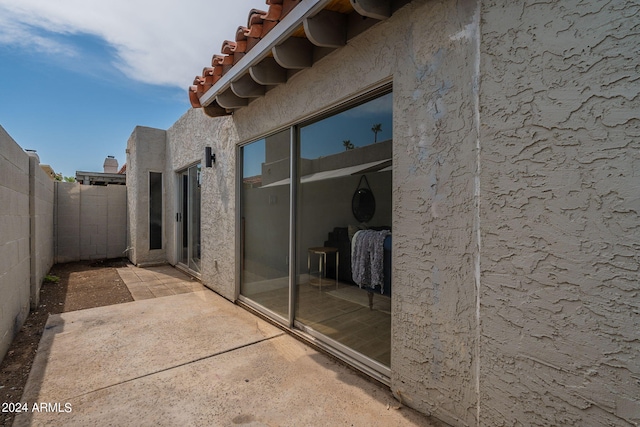 exterior space featuring a patio area, a fenced backyard, a tile roof, and stucco siding