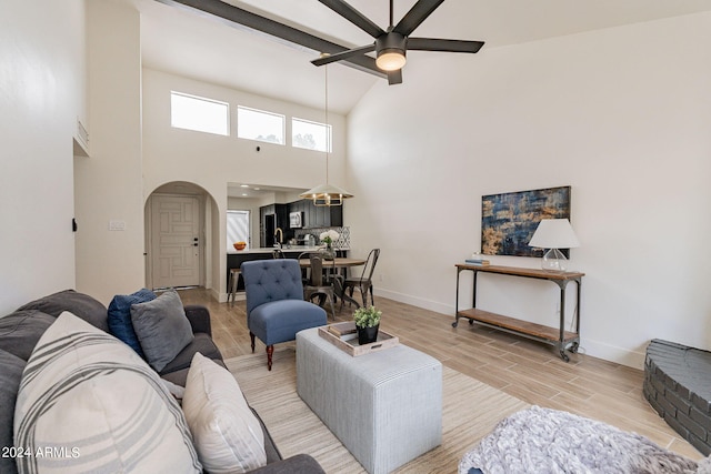 living area with a ceiling fan, baseboards, arched walkways, and wood tiled floor