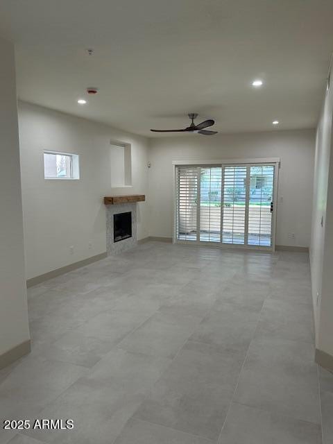 unfurnished living room with recessed lighting, a fireplace, a ceiling fan, and baseboards