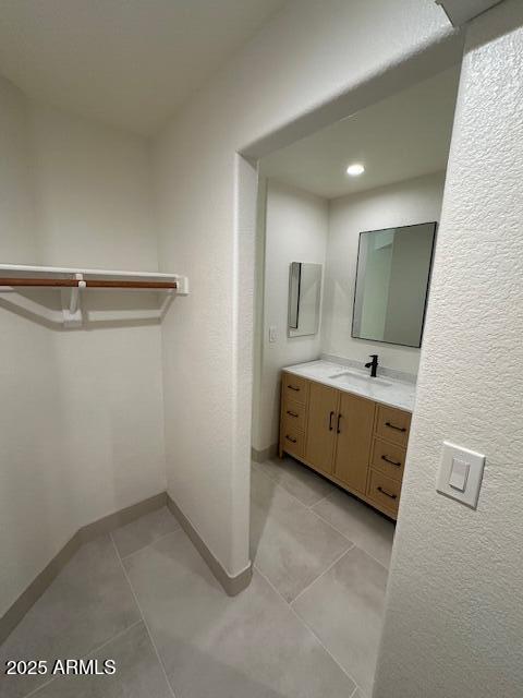 bathroom featuring vanity, baseboards, and tile patterned floors