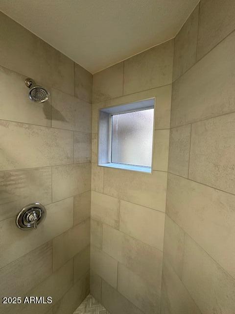 bathroom with tiled shower