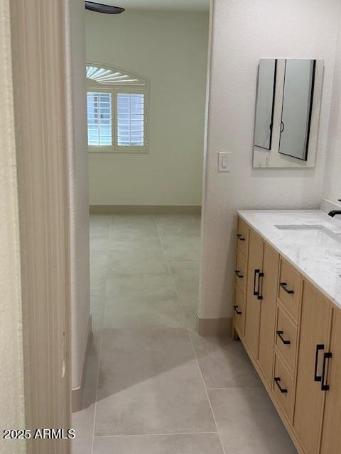 bathroom featuring tile patterned flooring, vanity, and baseboards