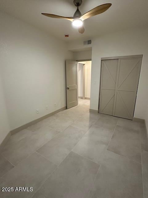 unfurnished bedroom featuring baseboards, visible vents, ceiling fan, and a closet