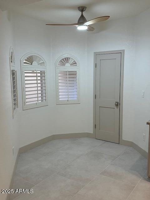 unfurnished room featuring light tile patterned floors, ceiling fan, and baseboards