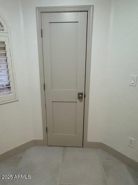 interior space featuring baseboards and light tile patterned floors