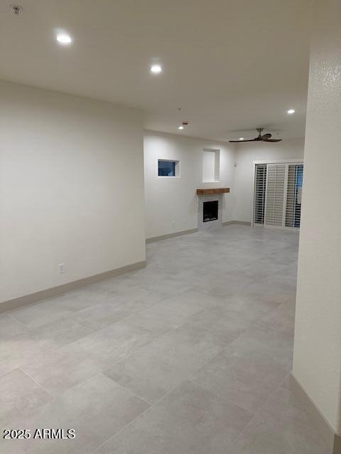 empty room with a fireplace, baseboards, and recessed lighting