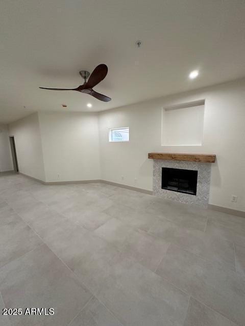 unfurnished living room featuring a premium fireplace, recessed lighting, a ceiling fan, and baseboards