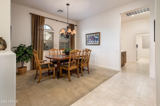 carpeted dining room featuring an inviting chandelier