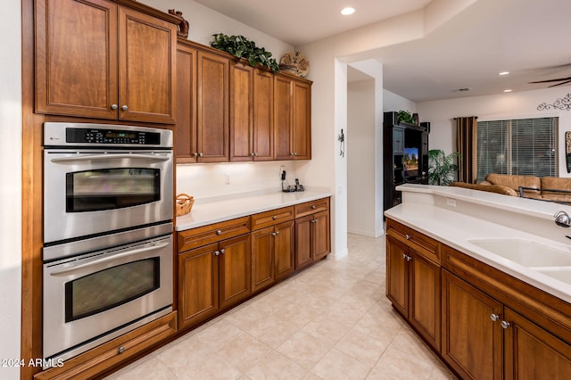 kitchen with ceiling fan, sink, and stainless steel double oven