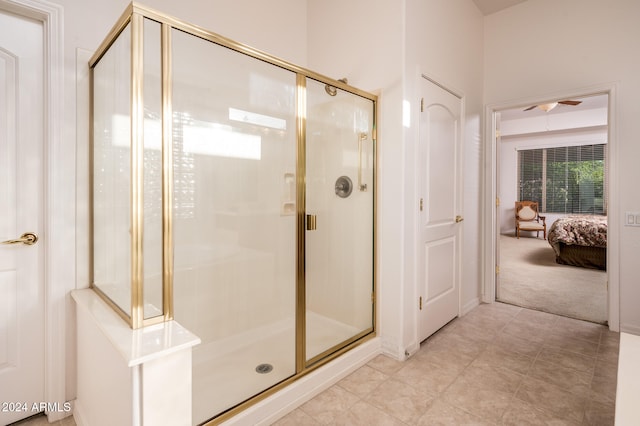 bathroom with ceiling fan and a shower with door