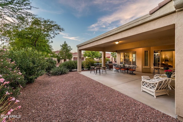 yard at dusk featuring outdoor lounge area and a patio area