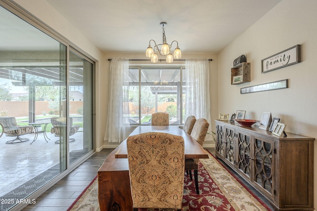 dining room with wood finished floors, baseboards, and an inviting chandelier