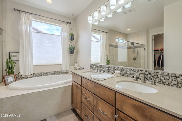 full bathroom with a garden tub, a shower stall, decorative backsplash, and a sink