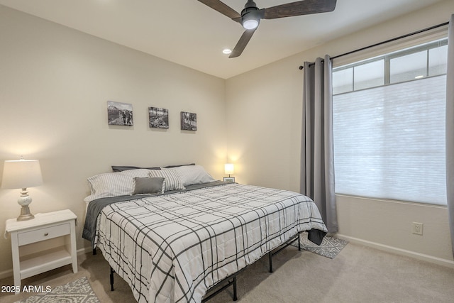 carpeted bedroom featuring baseboards and a ceiling fan