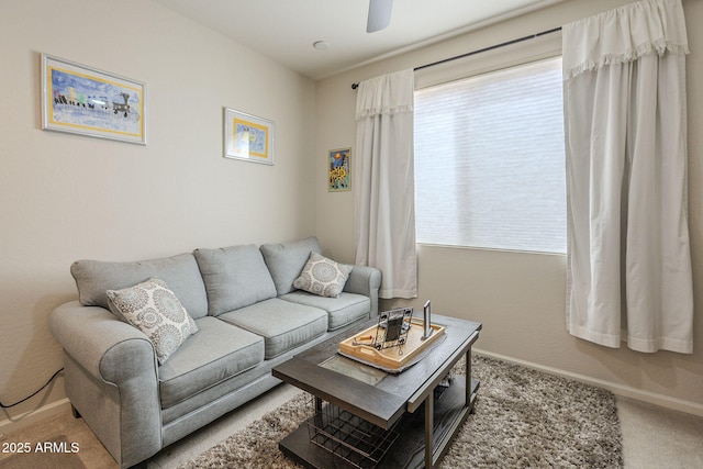 living area featuring carpet floors, ceiling fan, and baseboards