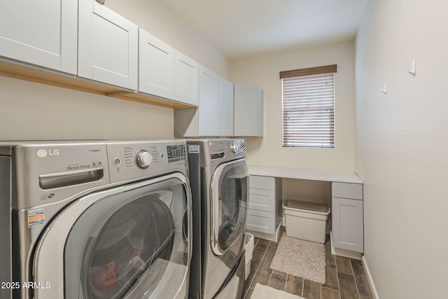 laundry room featuring baseboards, wood finish floors, cabinet space, and washer and dryer