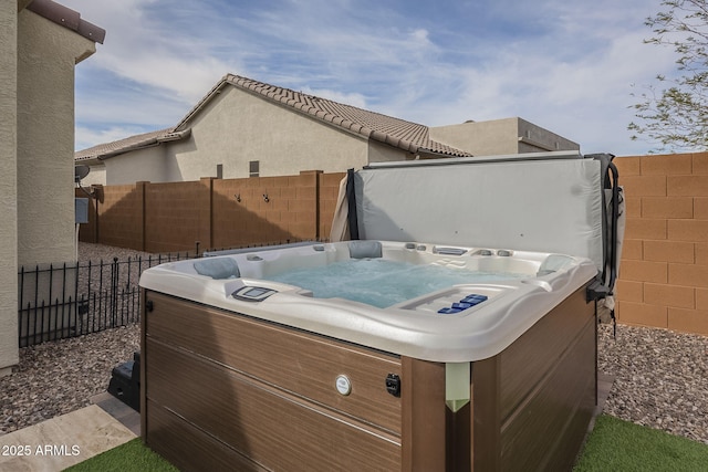 exterior space with fence and a hot tub