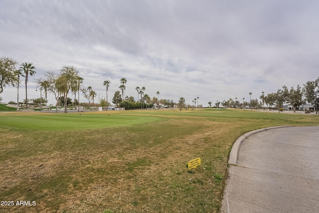 view of property's community with a yard and golf course view