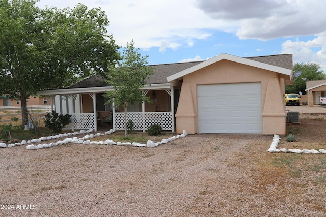 ranch-style house featuring a garage and cooling unit