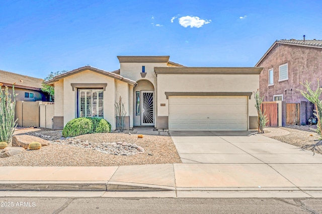 view of front facade with stucco siding, driveway, a garage, and fence