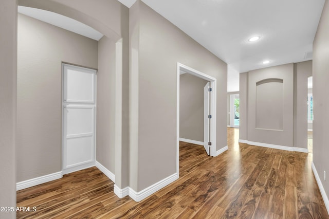 entryway featuring wood finished floors, baseboards, plenty of natural light, recessed lighting, and arched walkways