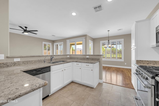 kitchen with stainless steel appliances, a sink, recessed lighting, baseboards, and white cabinets