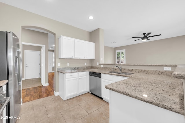 kitchen featuring appliances with stainless steel finishes, a sink, ceiling fan, light stone counters, and white cabinetry