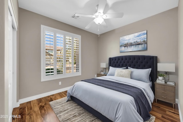 bedroom featuring baseboards, wood finished floors, and ceiling fan