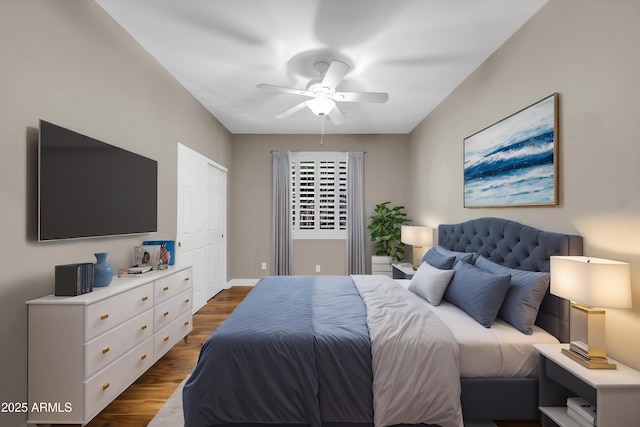 bedroom featuring dark wood-style floors, a ceiling fan, and baseboards