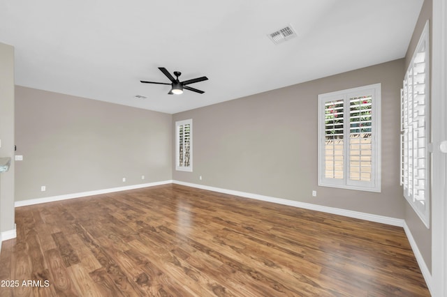 empty room with wood finished floors, ceiling fan, and baseboards
