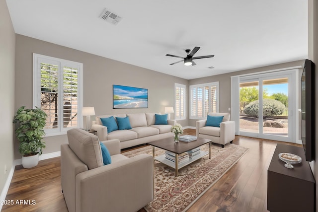 living room featuring plenty of natural light, wood finished floors, and ceiling fan