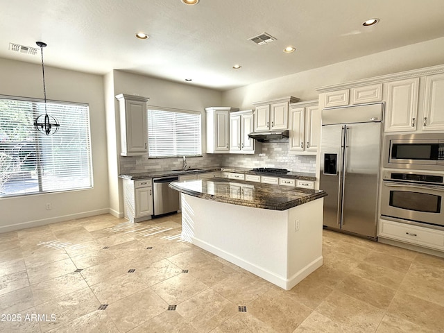 22903 N 39th Ter, Phoenix, AZ 85050 - kitchen with built in appliances, decorative backsplash, a center island, recessed lighting, and under cabinet range hood