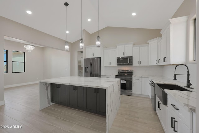 kitchen featuring appliances with stainless steel finishes, a sink, white cabinetry, and a center island