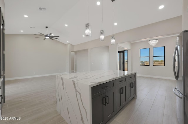 kitchen featuring a center island, lofted ceiling, visible vents, freestanding refrigerator, and open floor plan