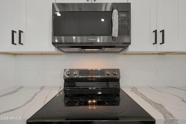 kitchen featuring appliances with stainless steel finishes, tasteful backsplash, white cabinets, and light stone countertops