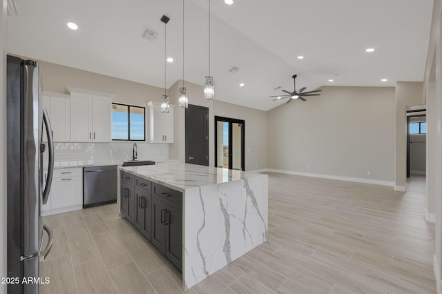 kitchen with dishwashing machine, visible vents, white cabinetry, freestanding refrigerator, and a center island