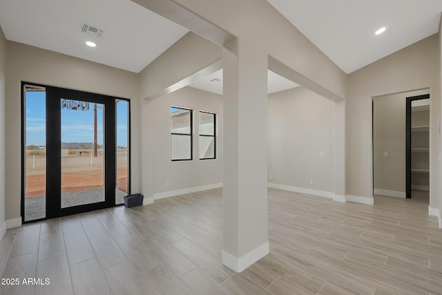 empty room featuring baseboards, vaulted ceiling, recessed lighting, and wood tiled floor