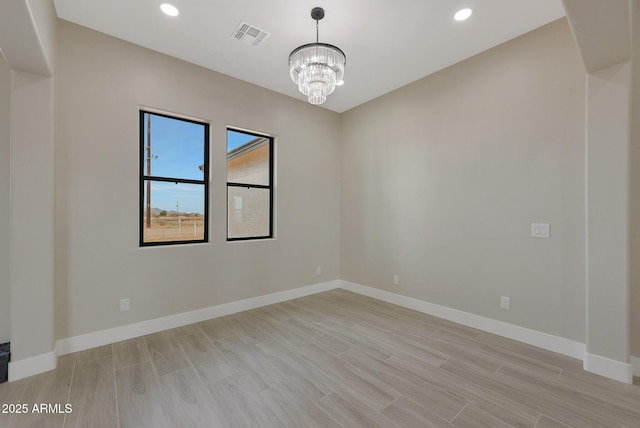 unfurnished room with baseboards, visible vents, and light wood-style floors