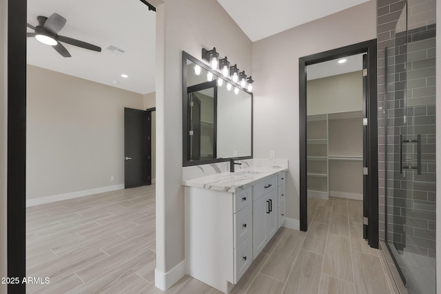 bathroom featuring a ceiling fan, baseboards, vanity, wood tiled floor, and a stall shower