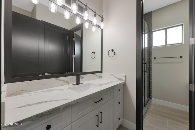 bathroom featuring a shower stall, vanity, and baseboards