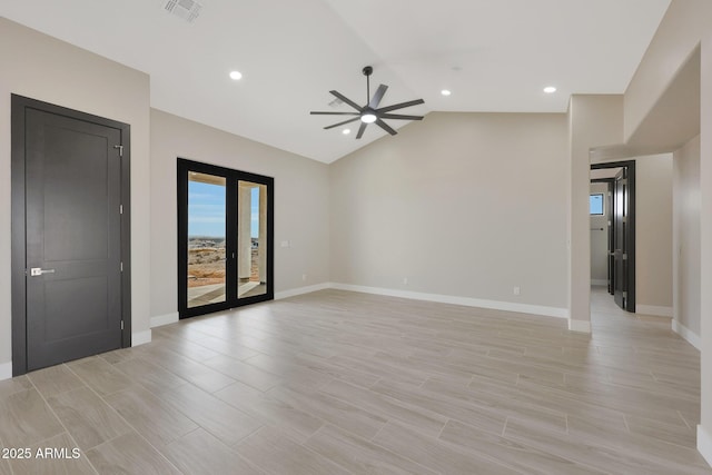 spare room with lofted ceiling, visible vents, baseboards, and wood finish floors