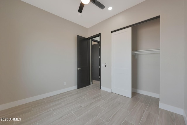 unfurnished bedroom with wood tiled floor, a closet, and baseboards