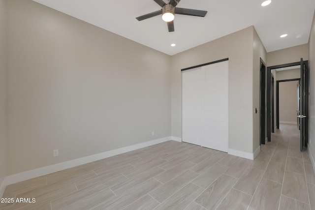 unfurnished bedroom with recessed lighting, a closet, wood tiled floor, and baseboards