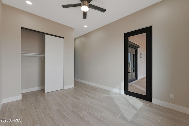 unfurnished bedroom featuring wood finish floors, a closet, and baseboards