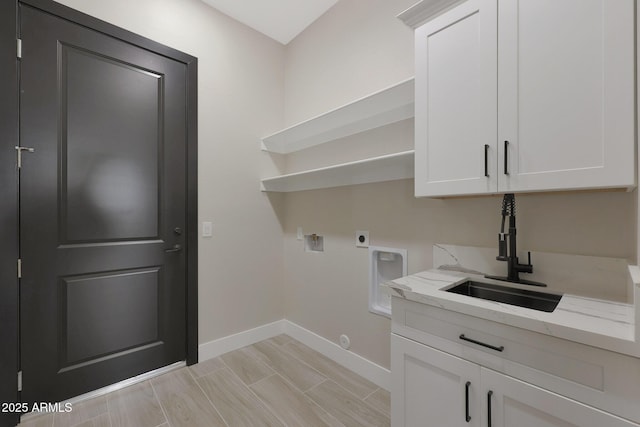 laundry room with hookup for a washing machine, cabinet space, a sink, electric dryer hookup, and baseboards