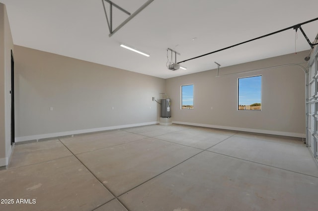 garage with water heater, a garage door opener, and baseboards