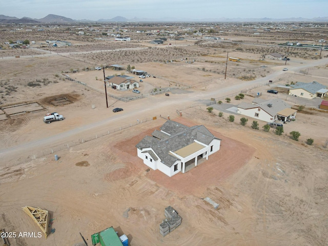 drone / aerial view featuring a mountain view and a desert view