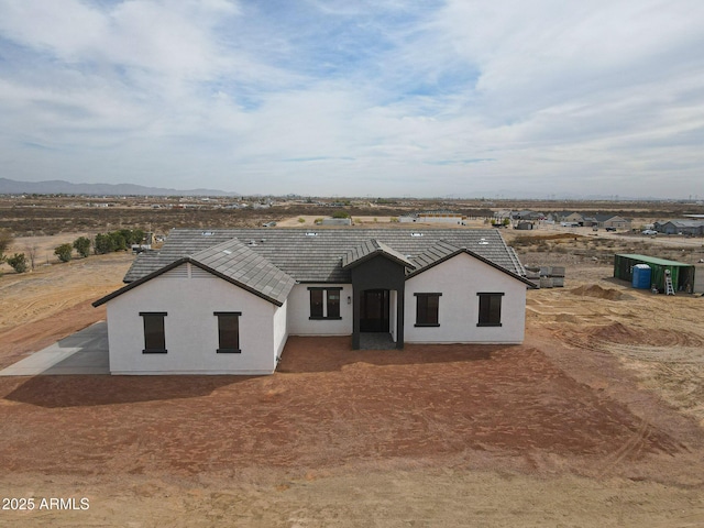 view of front facade featuring a tiled roof and stucco siding