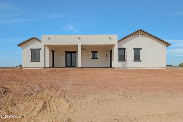 rear view of property featuring ceiling fan, french doors, and stucco siding