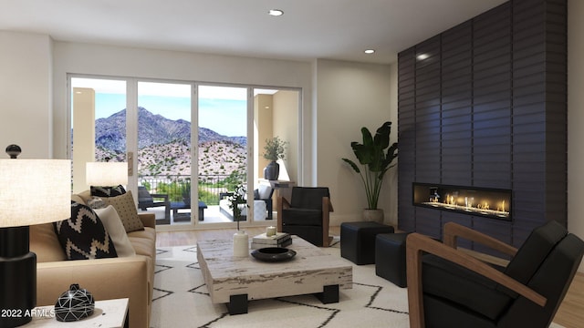 living room featuring a mountain view, light hardwood / wood-style flooring, a fireplace, and a wealth of natural light